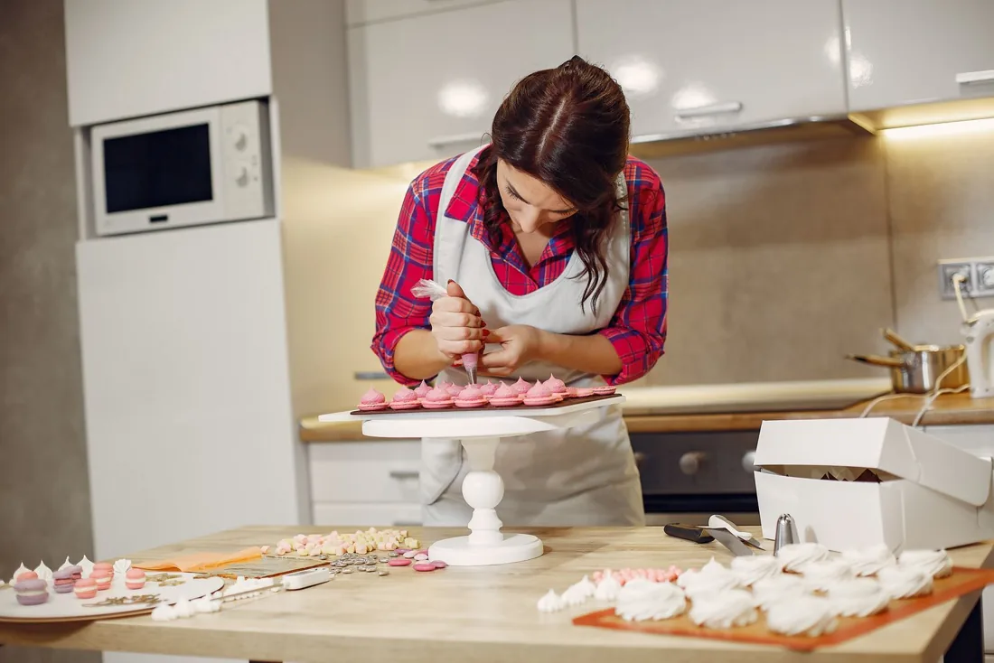 Tezgâhta cupcake süsleyen pastacı